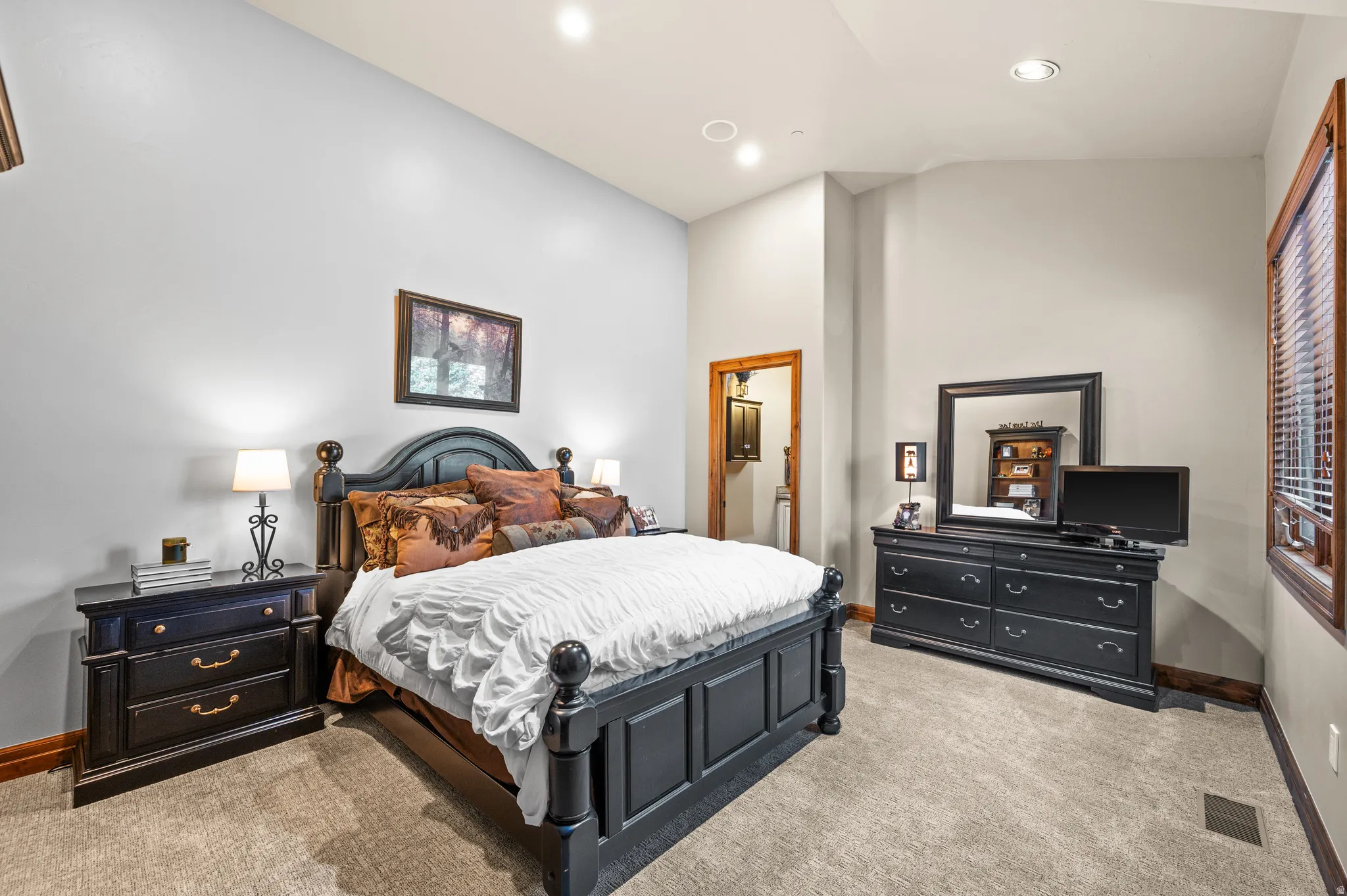 Bedroom featuring light colored carpet, lofted ceiling, and recessed lighting