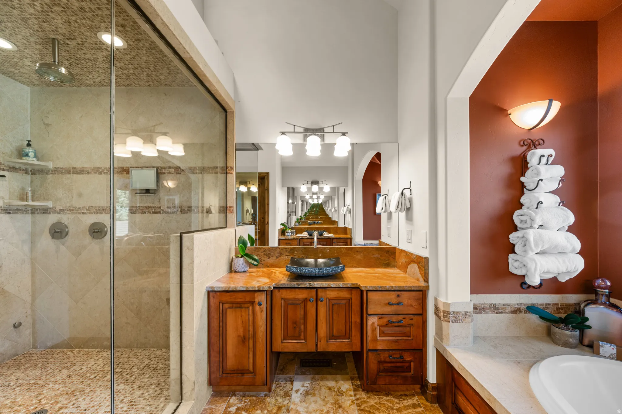 Bathroom with vanity, a shower stall, a bath, and light stone finish floors