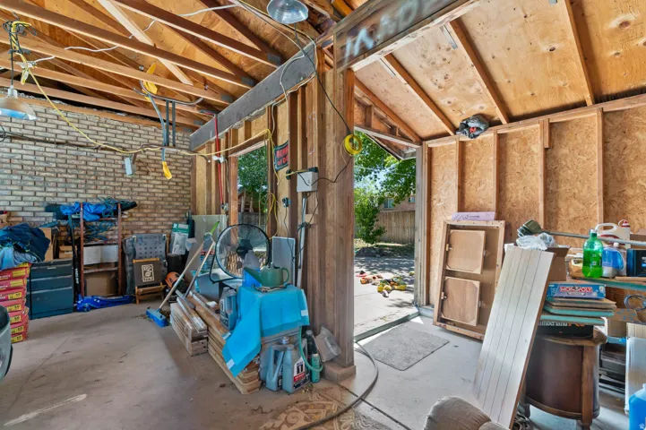 Exposed wood ceiling beams, plywood wall construction, and a brick wall section