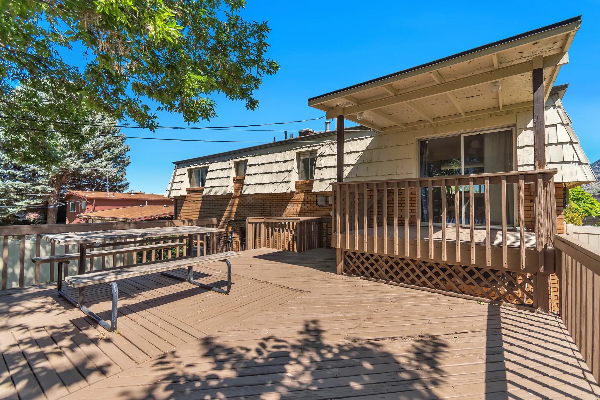 Expansive wood-finish deck with a built-in privacy screen, providing outdoor living space