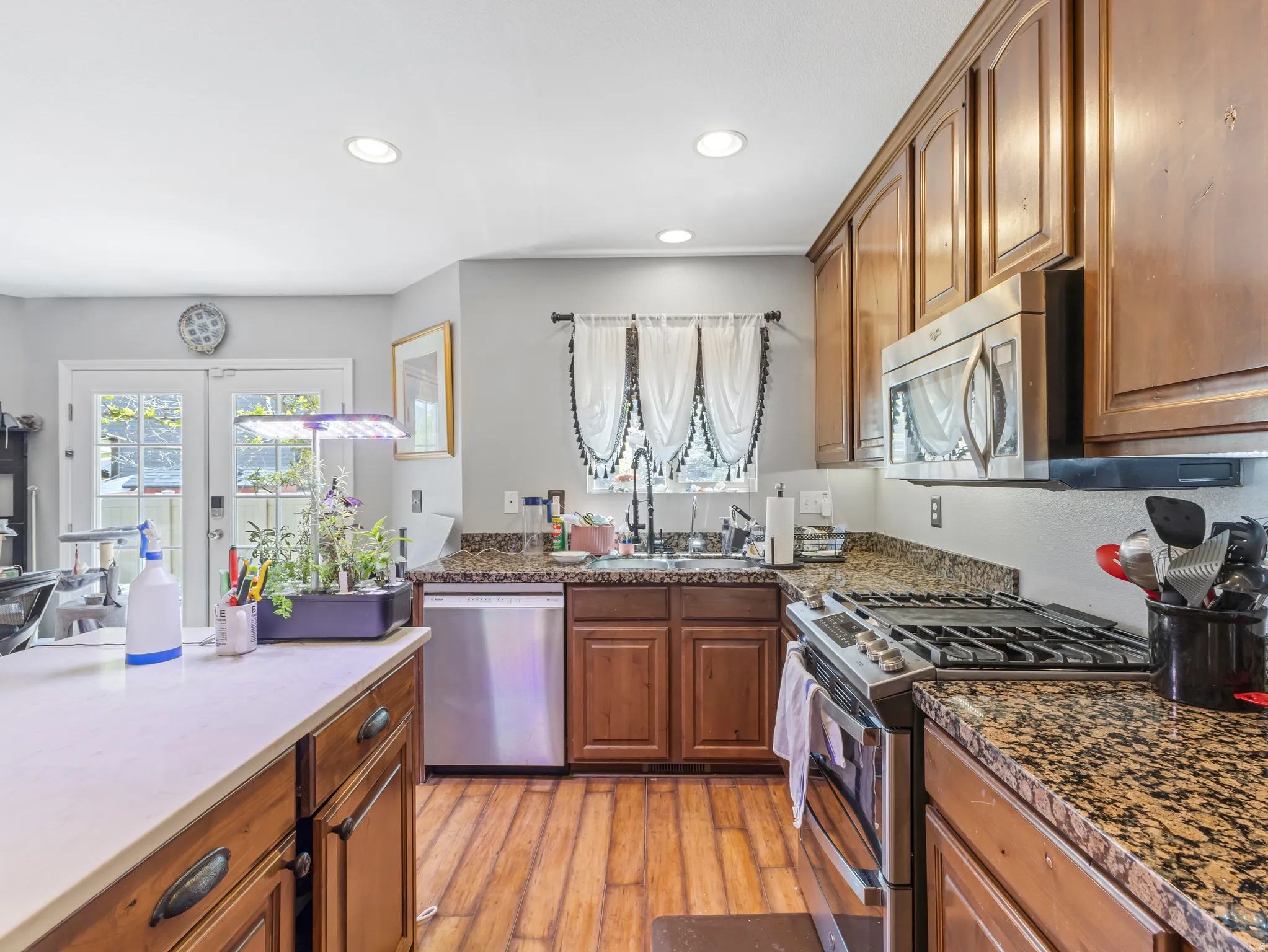 Well-appointed kitchen featuring wood-finish flooring, granite countertops, and stainless steel appliances