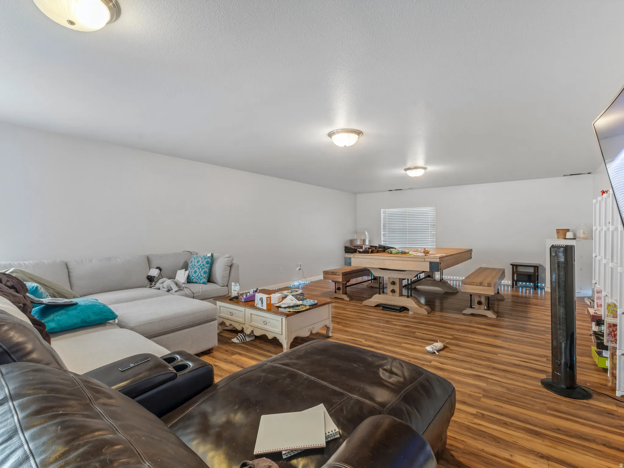 Open-concept room featuring wood-finish flooring, recessed lighting, and a window with horizontal blinds