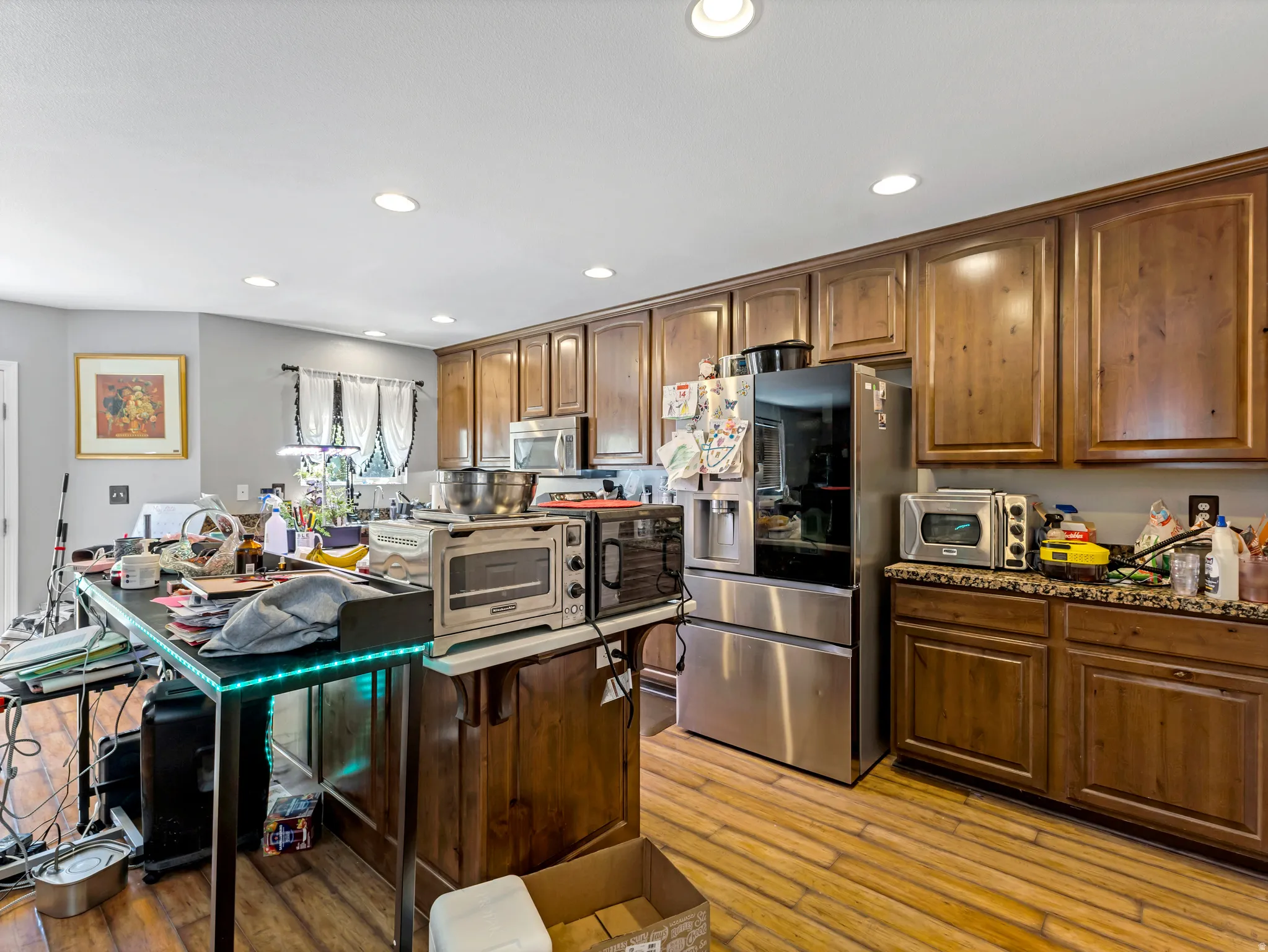 Kitchen featuring wood-finish flooring, recessed lighting, wood cabinetry, and a countertop with a speckled finish