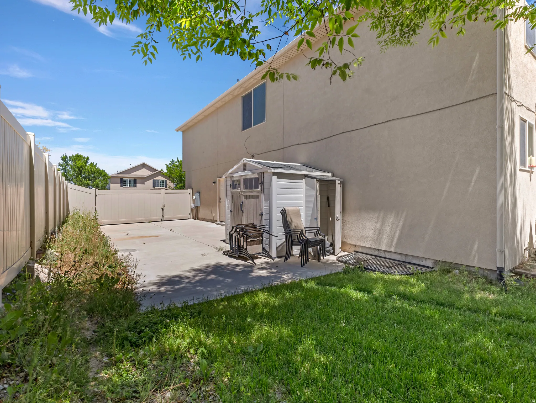 Expansive concrete patio with a detached storage shed