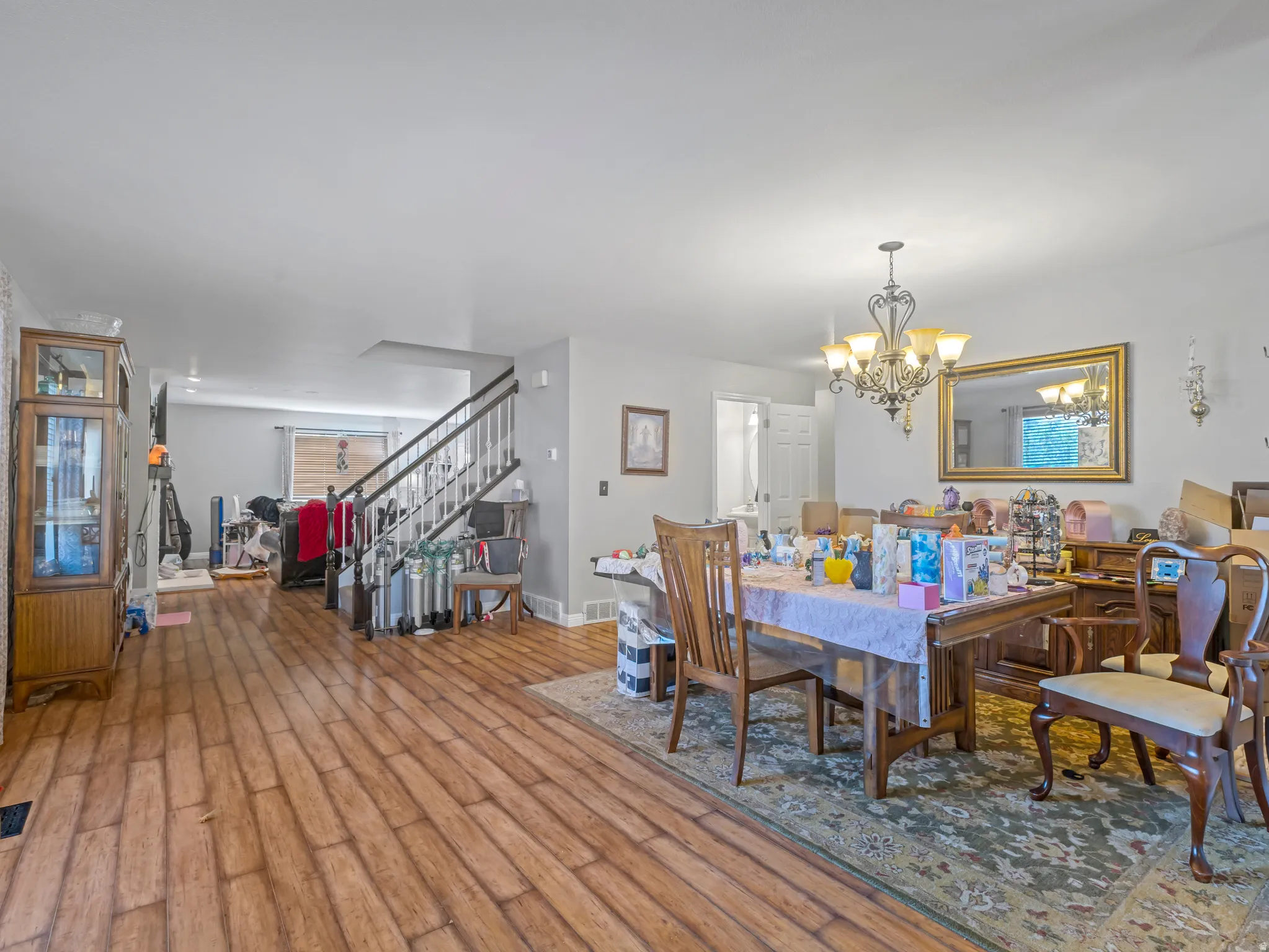 Wood-finish flooring throughout, featuring a staircase with white risers and dark banister
