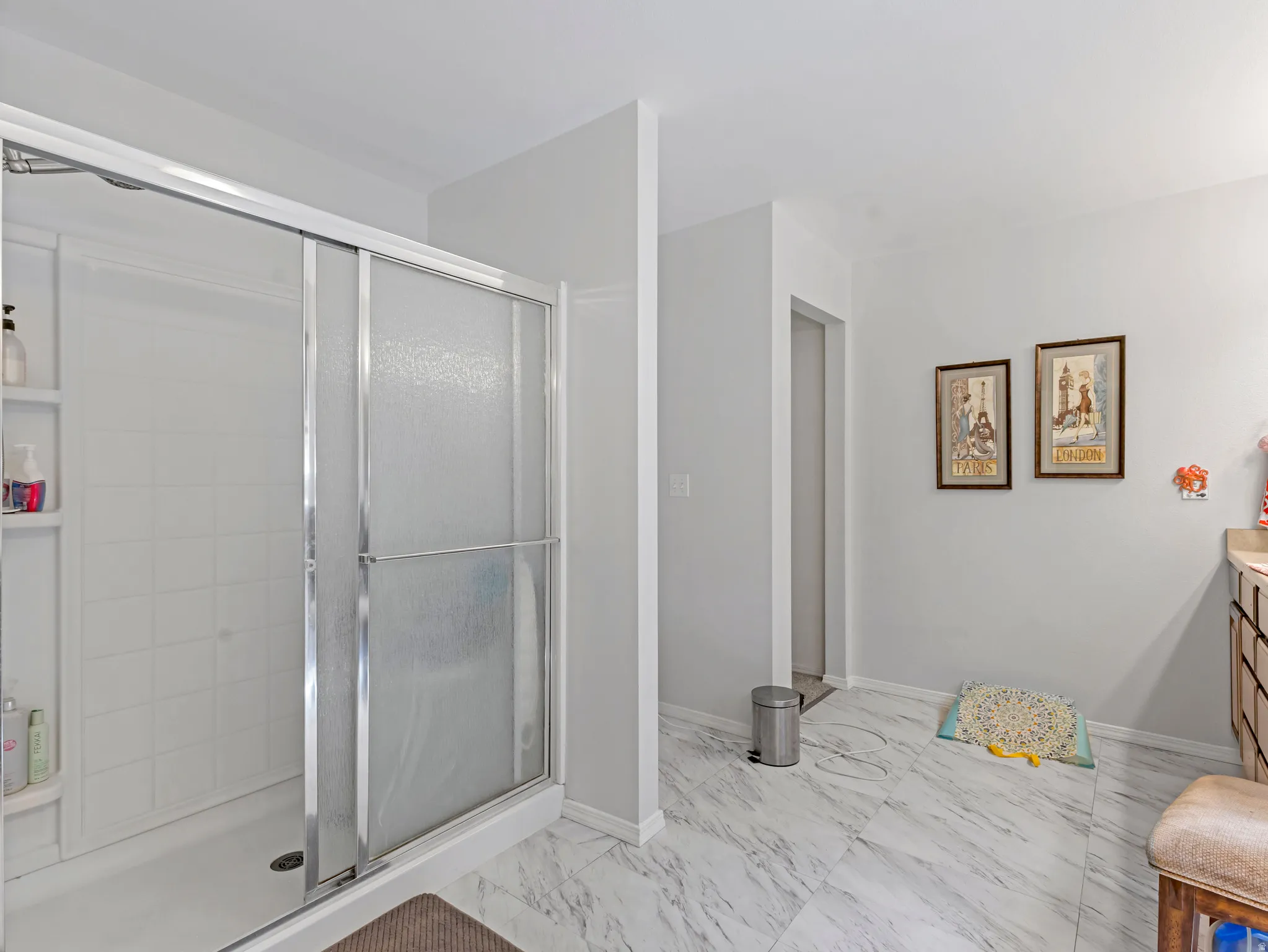 Shower enclosure with sliding frosted glass doors, white tiled interior, and integrated shelving