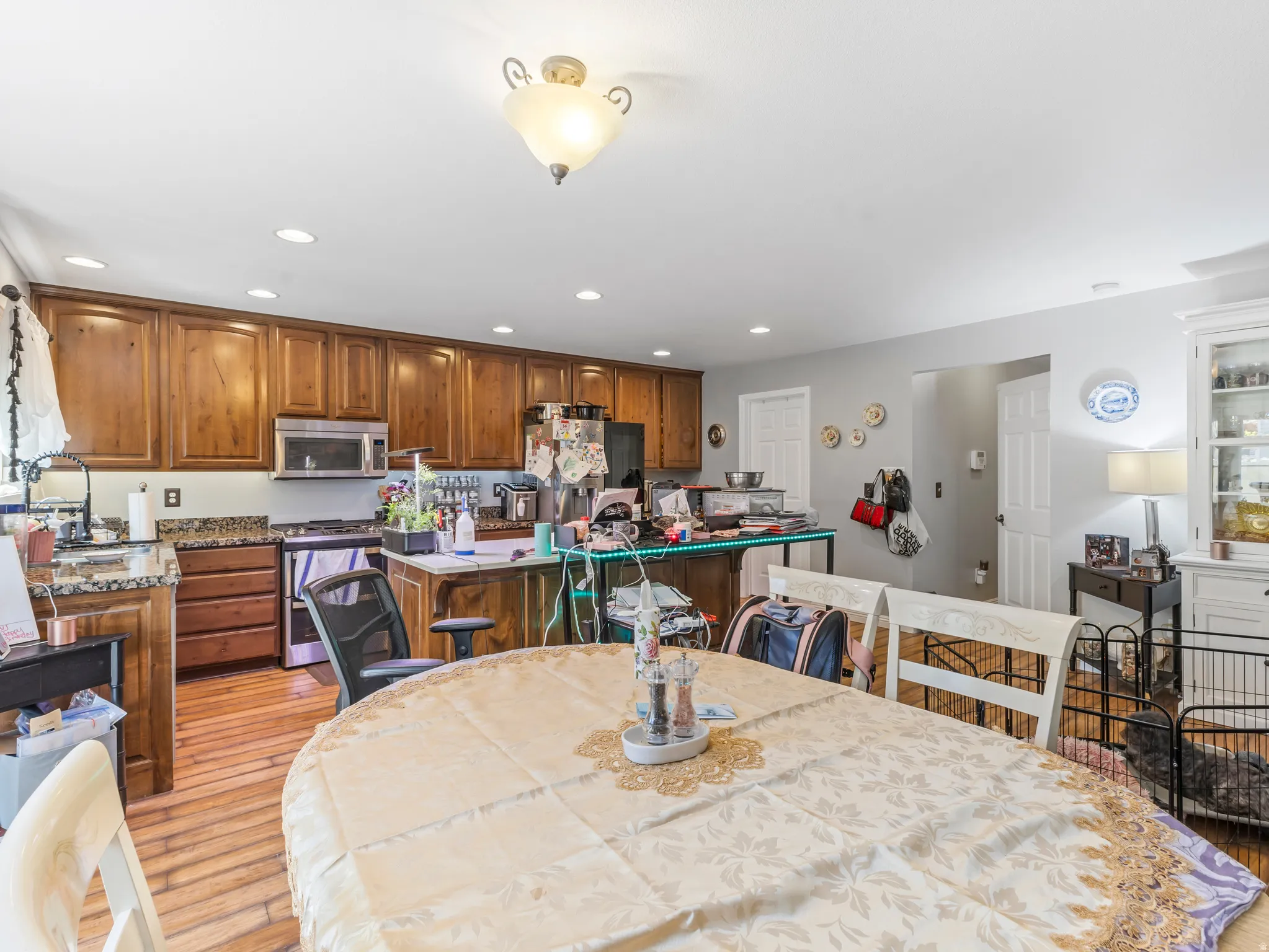 Kitchen featuring wood-finish cabinetry, granite-style countertops, and stainless steel appliances including a microwave and range