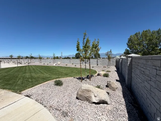 Private outdoor space featuring a lawn area, gravel landscaping, and several young trees