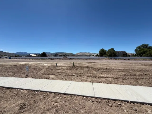 Cleared land parcel featuring level grading and a newly installed concrete sidewalk