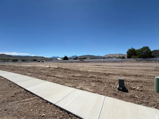 Expansive, cleared lot with a newly installed concrete sidewalk