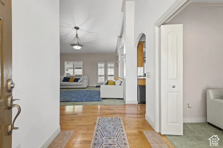 Hardwood flooring, recessed lighting, arched entryway, and a decorative light fixture