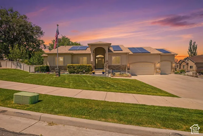 Contemporary stucco exterior featuring stone accents and an arched entry