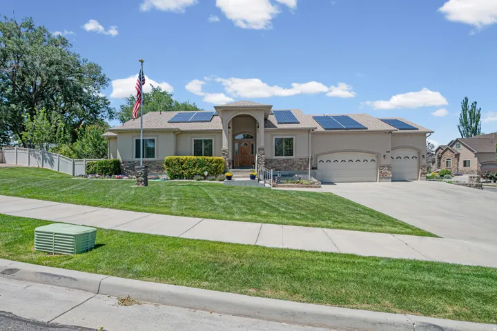 Ranch-style residence featuring a stucco exterior with stone accents, an arched entryway, and solar panels