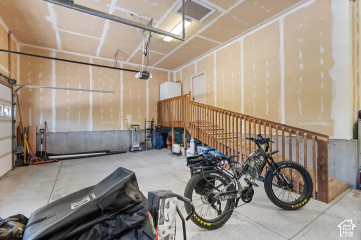 Garage with a built-in wooden staircase and railing