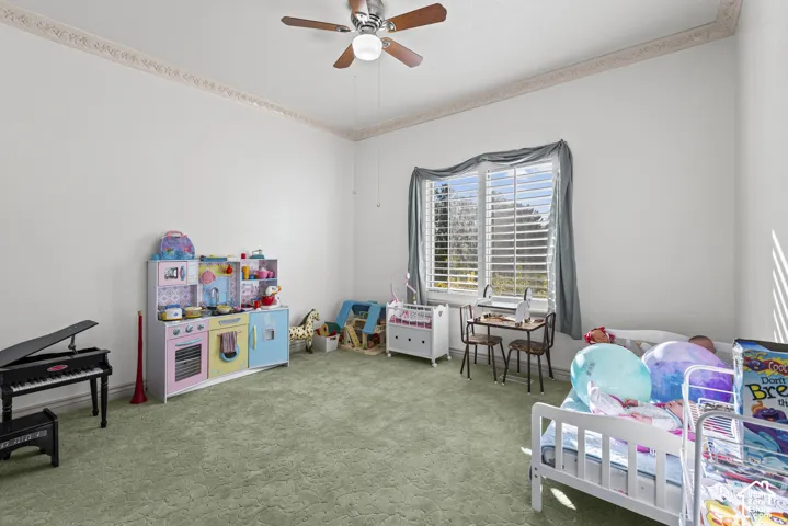 Crown molding, ceiling fan with integrated lighting, and wall-to-wall carpeting