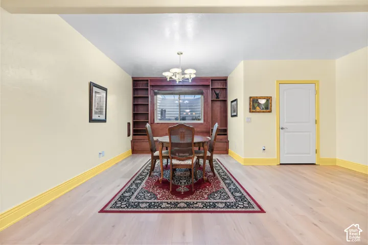 Light wood-finish flooring extending into a dining area with built-in wood shelving