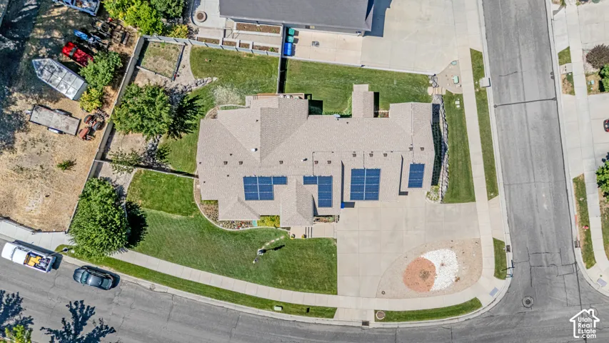 Aerial perspective showcasing a property with a multi-gabled roofline and multiple solar panel arrays