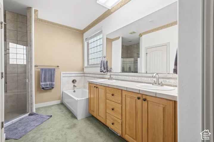 Dual vanity with integrated sinks, wood-finish cabinetry, and a large mirror