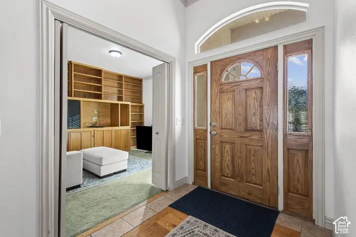 Arch-top wood entry door with glass inserts and side lites, complemented by an arched transom window