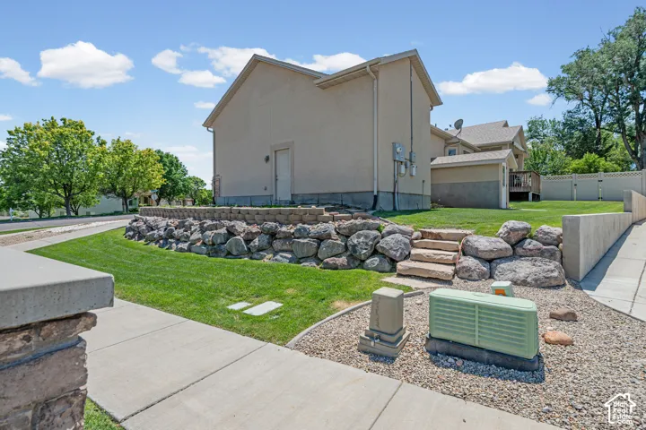 Manicured lawn with a rock retaining wall and integrated stone steps