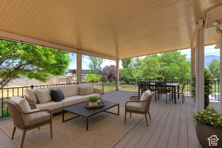 Expansive covered deck featuring composite wood-finish flooring and a full overhead ceiling