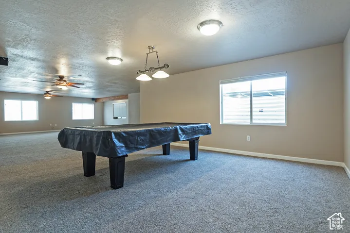 Spacious room with gray carpet flooring and neutral-toned walls