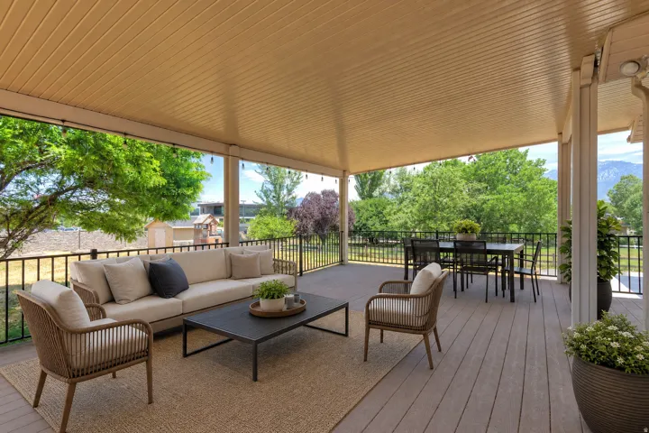 Expansive covered deck featuring composite wood-finish flooring and a full overhead ceiling
