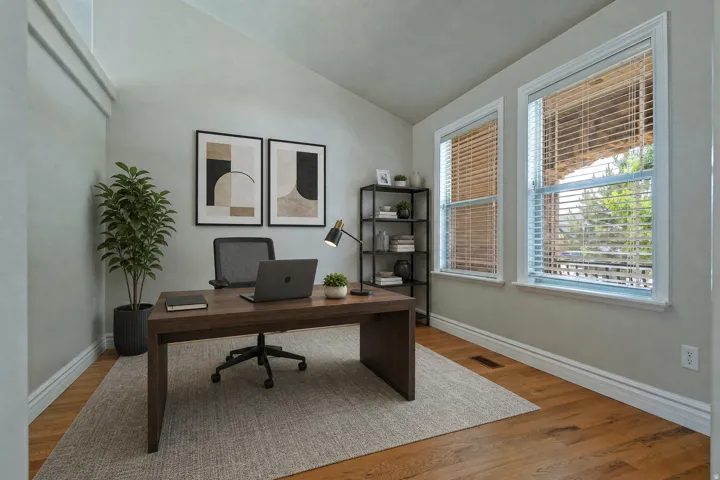 Dedicated office space featuring vaulted ceilings, wood-finish flooring, and white trim