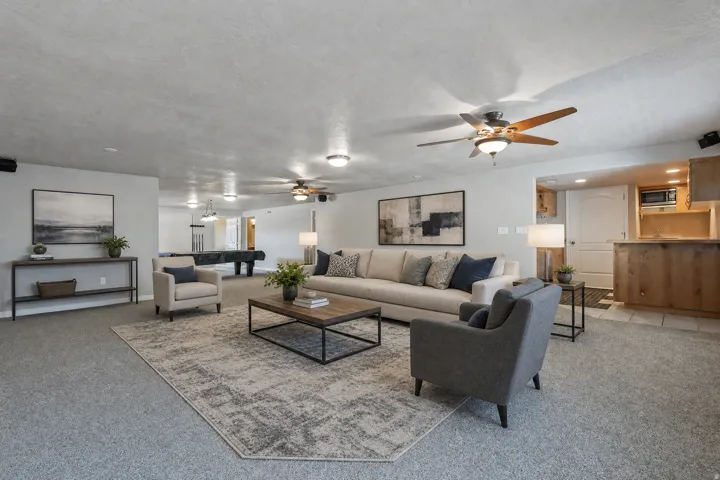 Open-concept living space featuring gray carpeting, recessed lighting, and ceiling fans