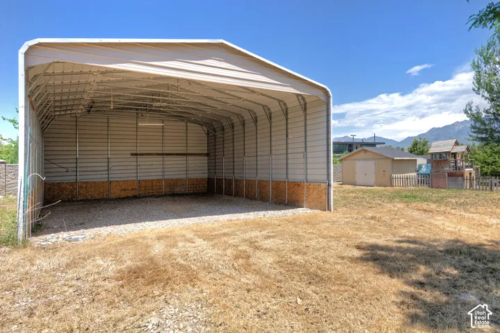 Expansive metal carport featuring a gravel floor and durable corrugated metal siding