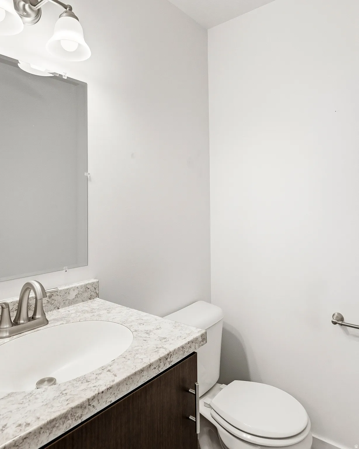 Bathroom vanity featuring a light-toned countertop, undermount sink, and brushed nickel faucet
