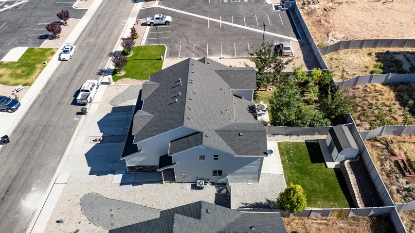 Two-story residence featuring a dark shingle roof, light-colored siding, and stone accents