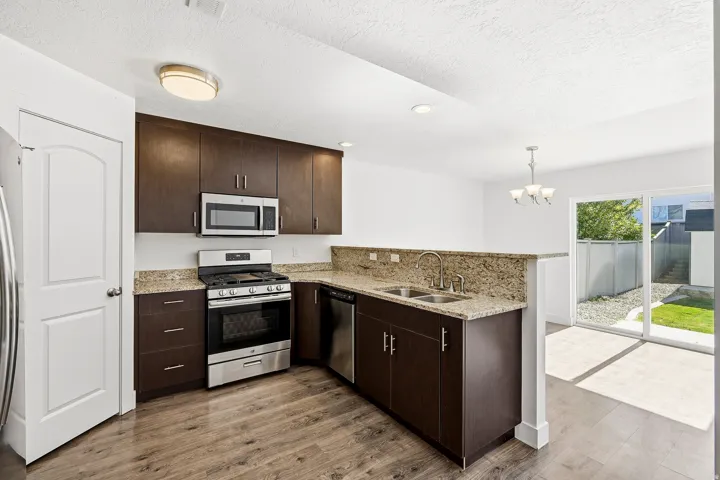 Modern kitchen featuring dark wood-finish cabinetry and stainless steel appliances
