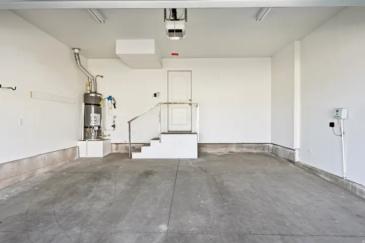 Spacious garage featuring a concrete floor, painted walls, and overhead fluorescent lighting