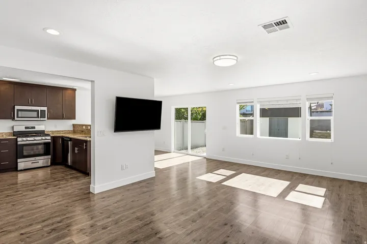 Open-concept living area featuring wood-finish flooring, recessed lighting, and a sliding glass door