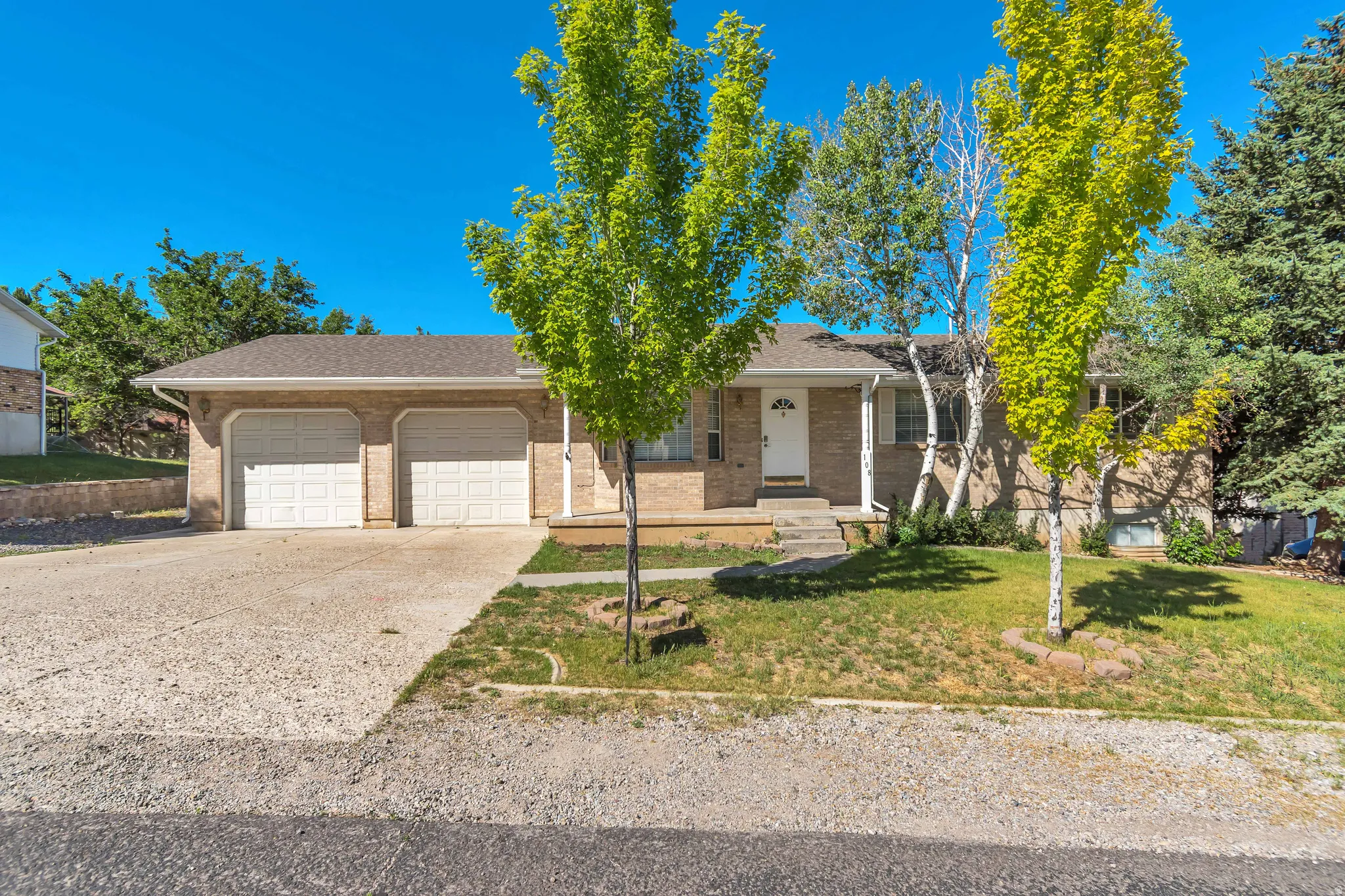 Brick exterior with a two-car garage and a concrete driveway
