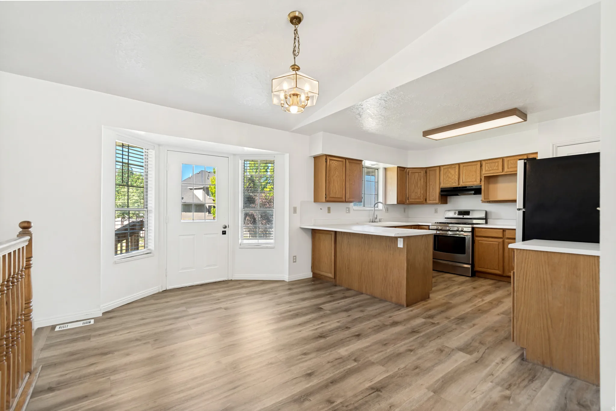 Open-concept kitchen and dining area featuring wood-finish flooring