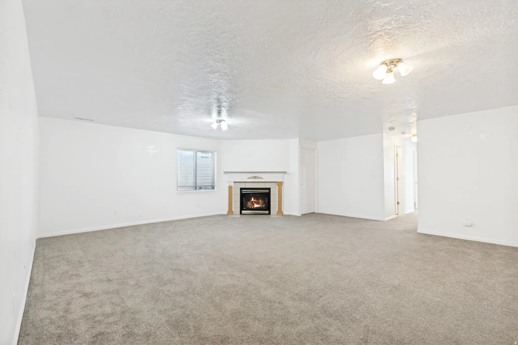 Spacious interior with neutral carpeting and white wall finishes