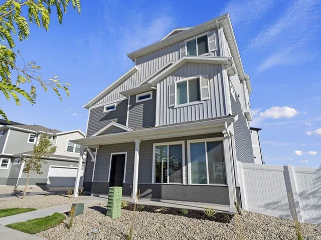 Contemporary three-story residence featuring a gray and light gray siding exterior