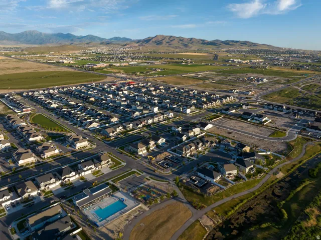 Expansive community featuring numerous residential structures, a large swimming pool with adjacent amenity building, and established street infrastructure