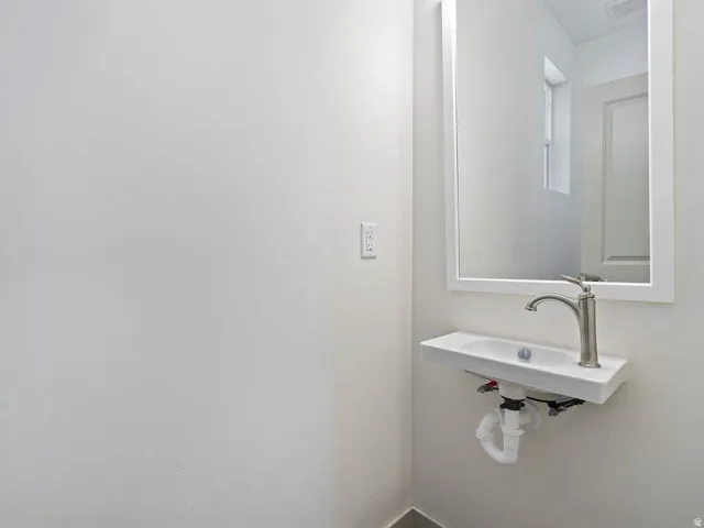 Wall-mounted rectangular sink with a single-handle brushed nickel faucet