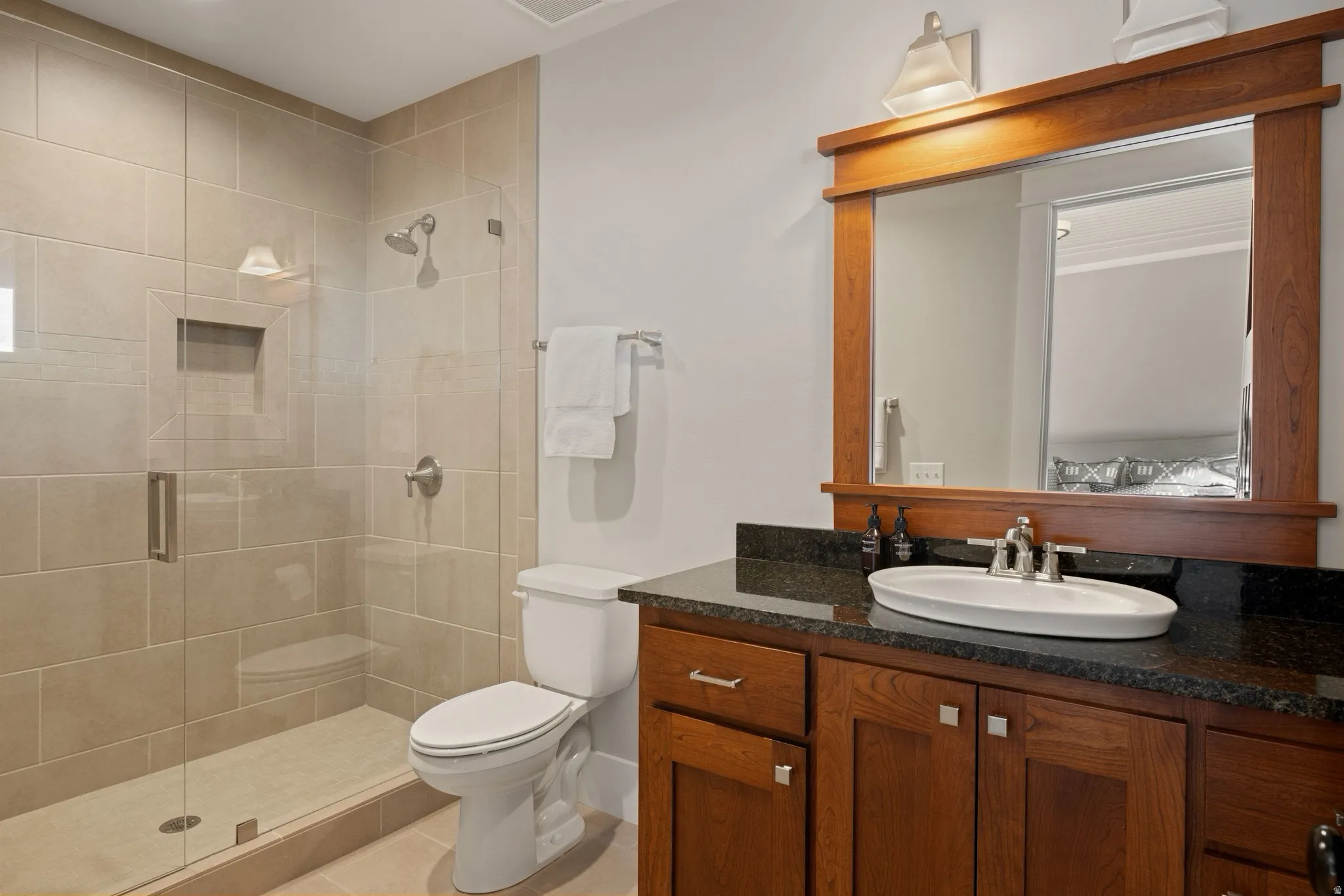 Modern bathroom featuring a walk-in shower with clear glass enclosure and tiled walls