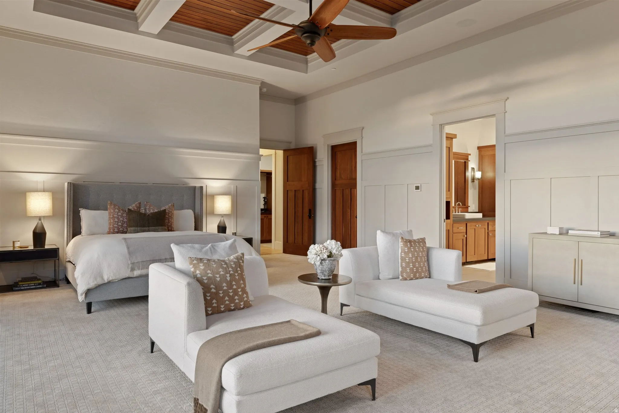 Expansive bedroom featuring a coffered ceiling with wood-paneled inserts and a ceiling fan