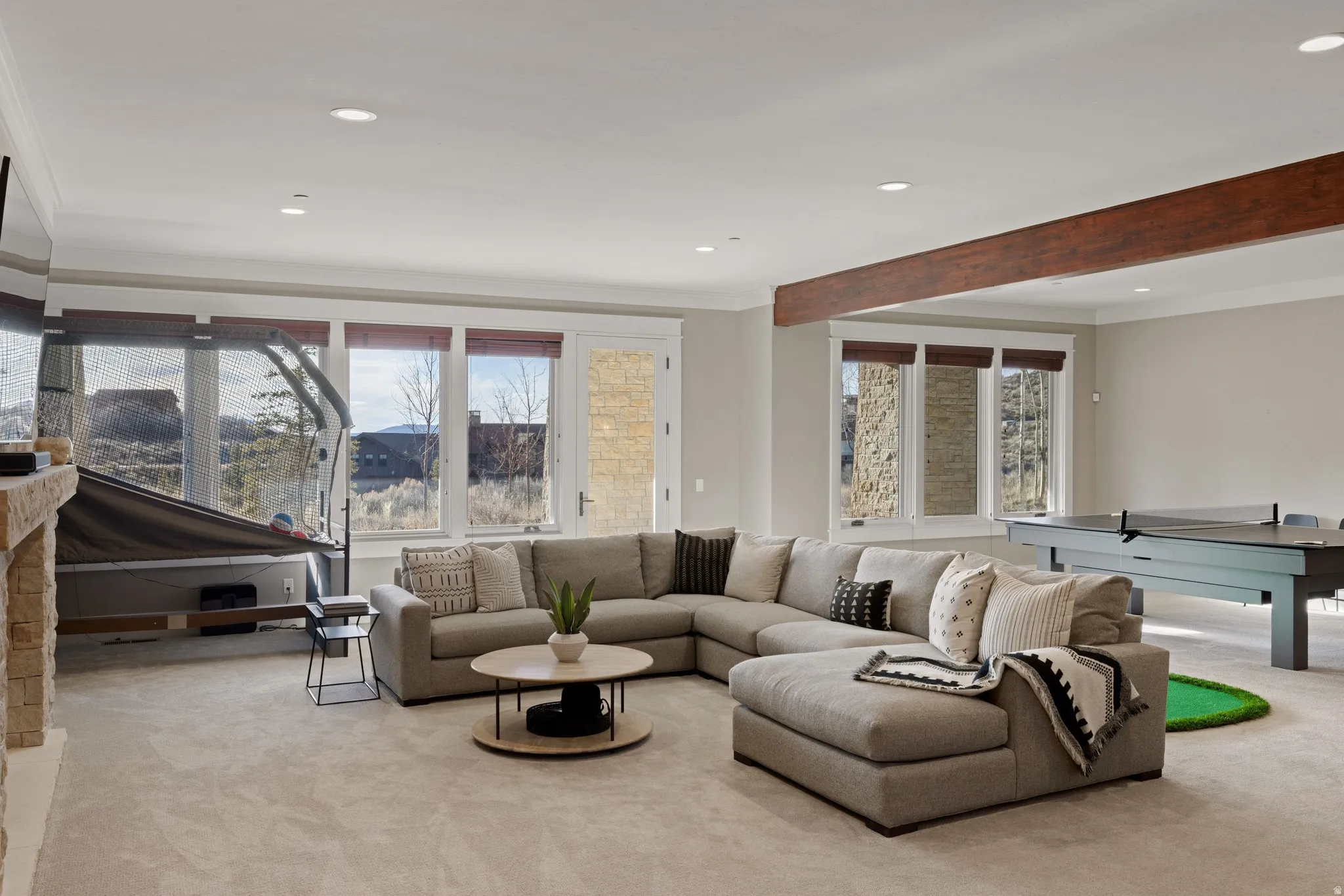 Spacious entertainment room featuring recessed lighting and a decorative wood beam
