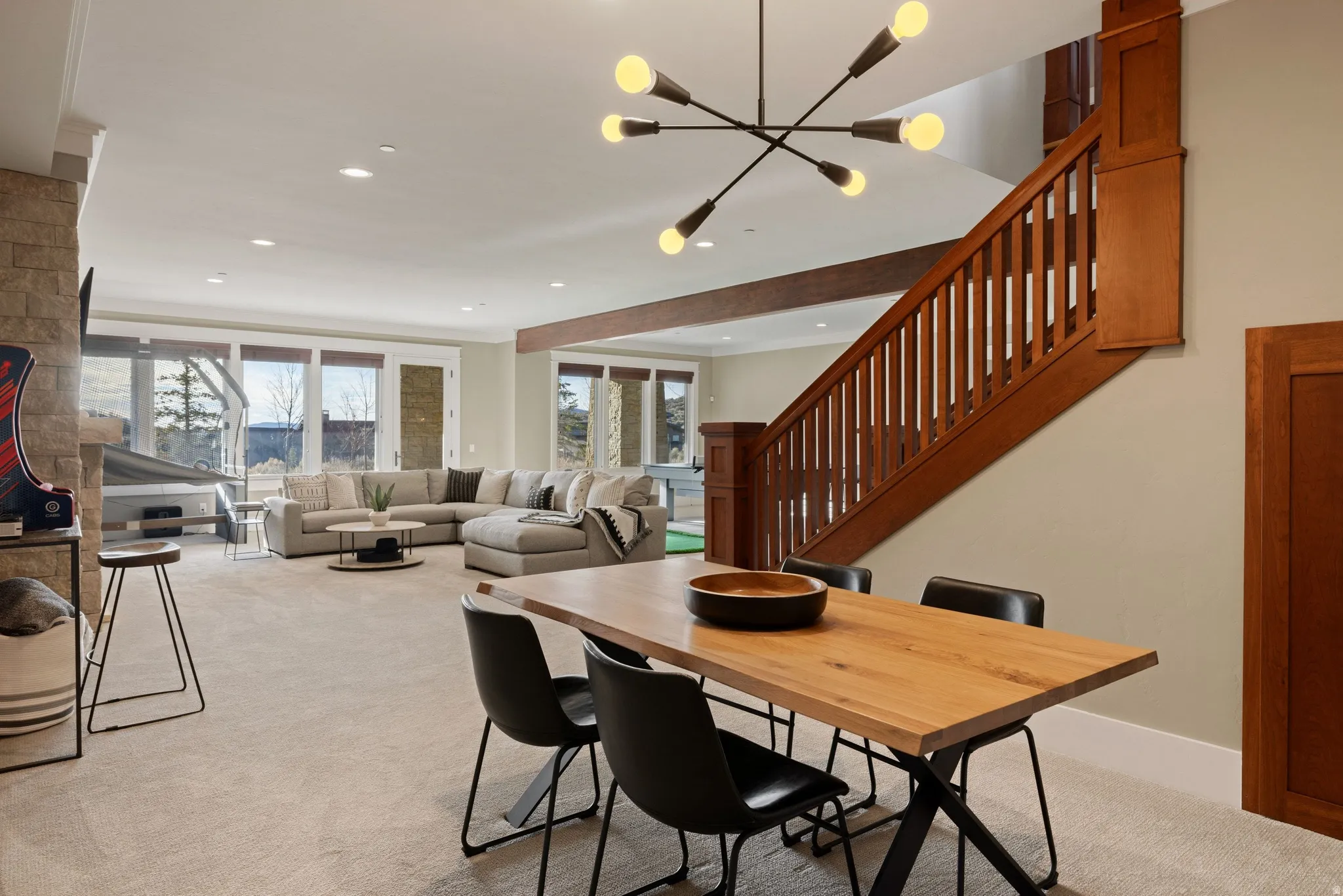 Open-concept living space featuring a wood-finish staircase, recessed lighting, and a contemporary light fixture
