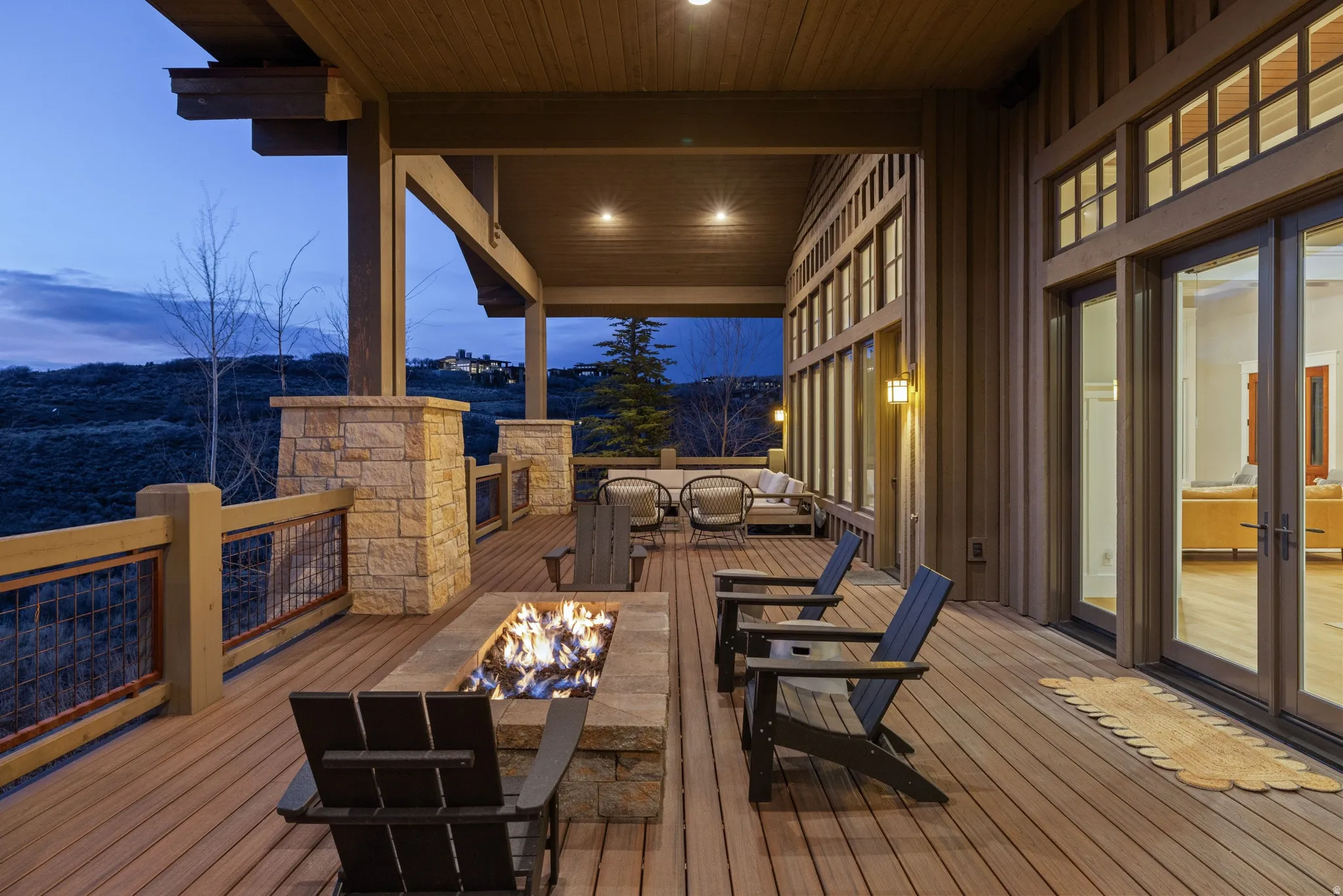 Expansive wood-finish deck featuring a stone-clad linear fire pit
