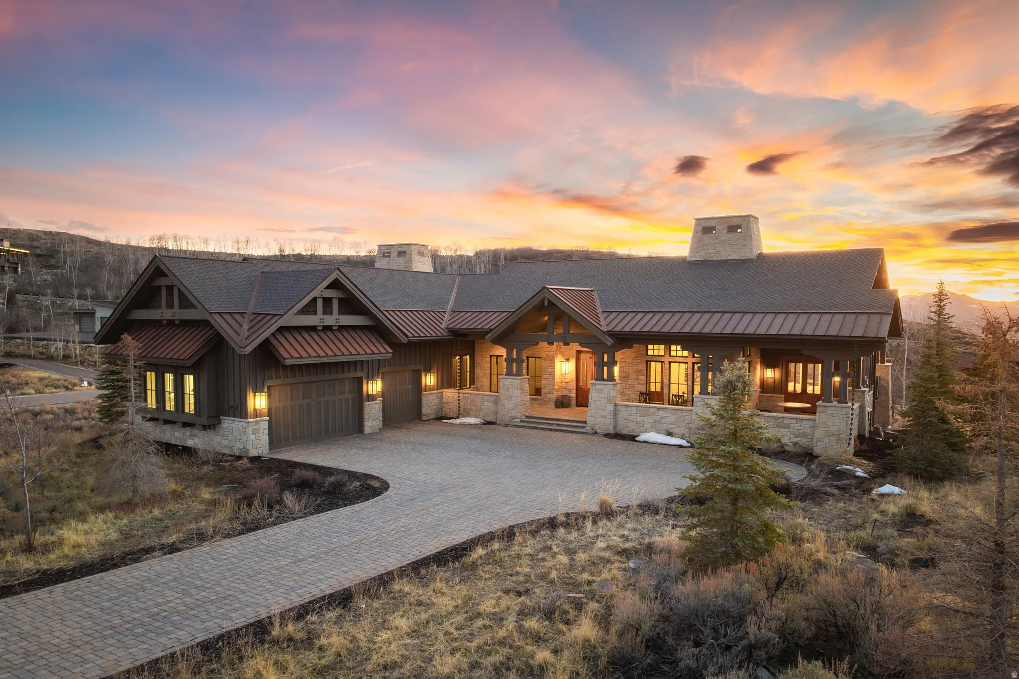 Mountain-style residence featuring a paved driveway, stone accents, and wood-finish siding