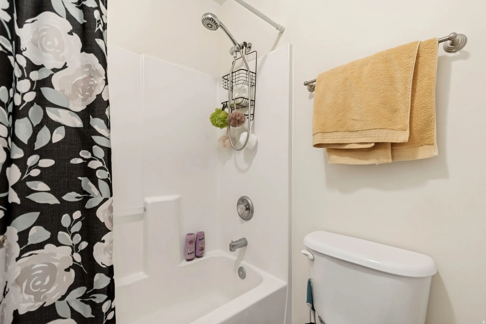 Full-size bathtub with a white surround and a chrome shower head fixture
