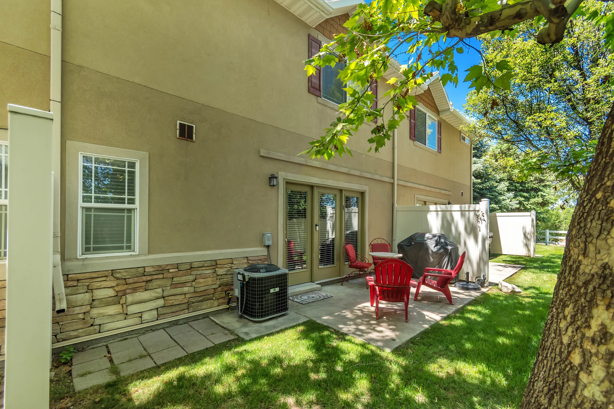 Rear exterior with a concrete patio featuring direct access through double glass doors