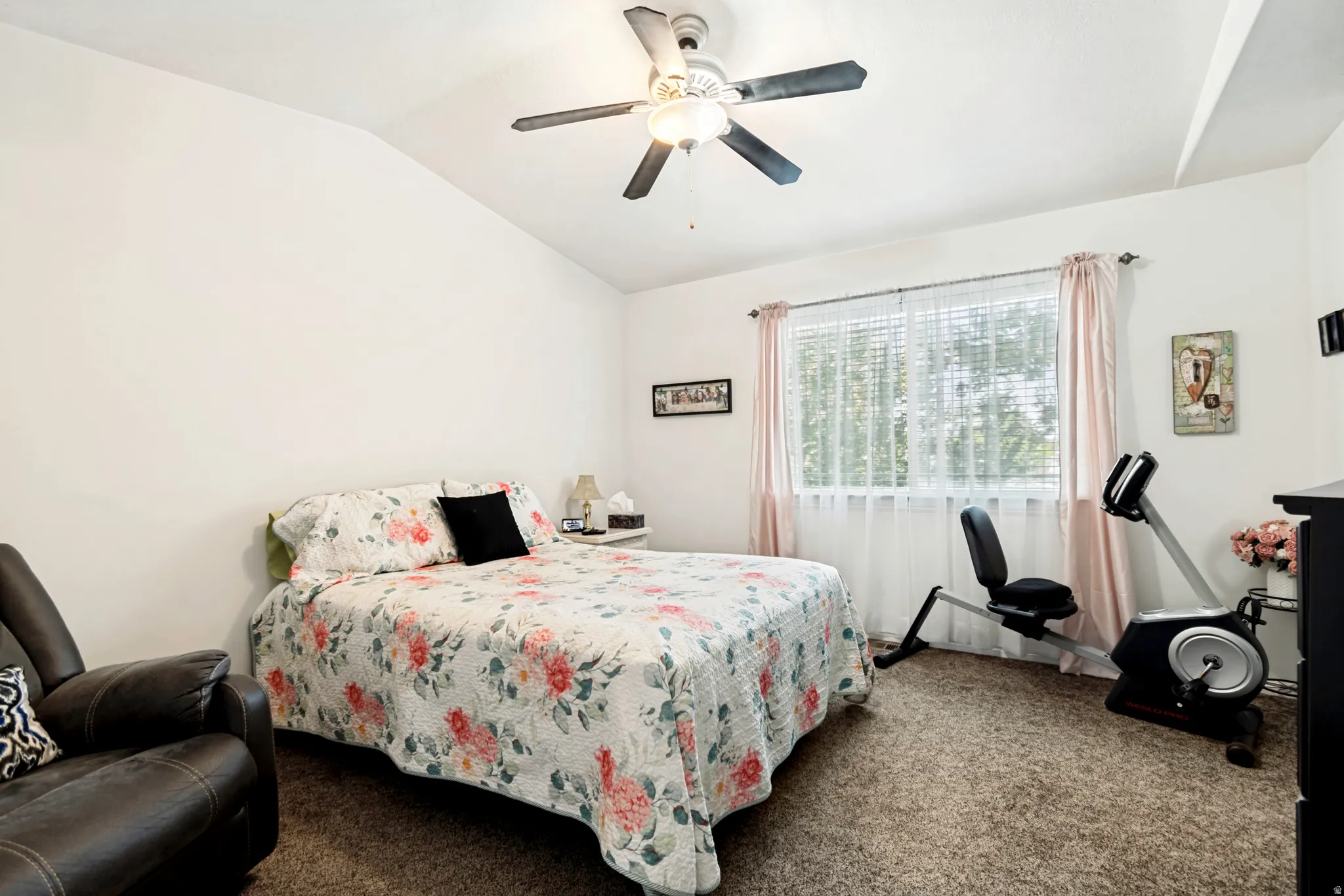 Bedroom featuring vaulted ceilings, a ceiling fan with integrated lighting, a window with horizontal blinds, and carpet flooring